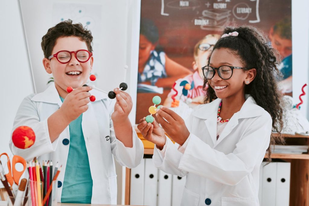 Improving science literacy means changing science education, but the current introductory science classes typically require students to memorize facts, rather than teaching them the basis of scientific thinking. This image shows two young school children learning about molecules in science class at school.