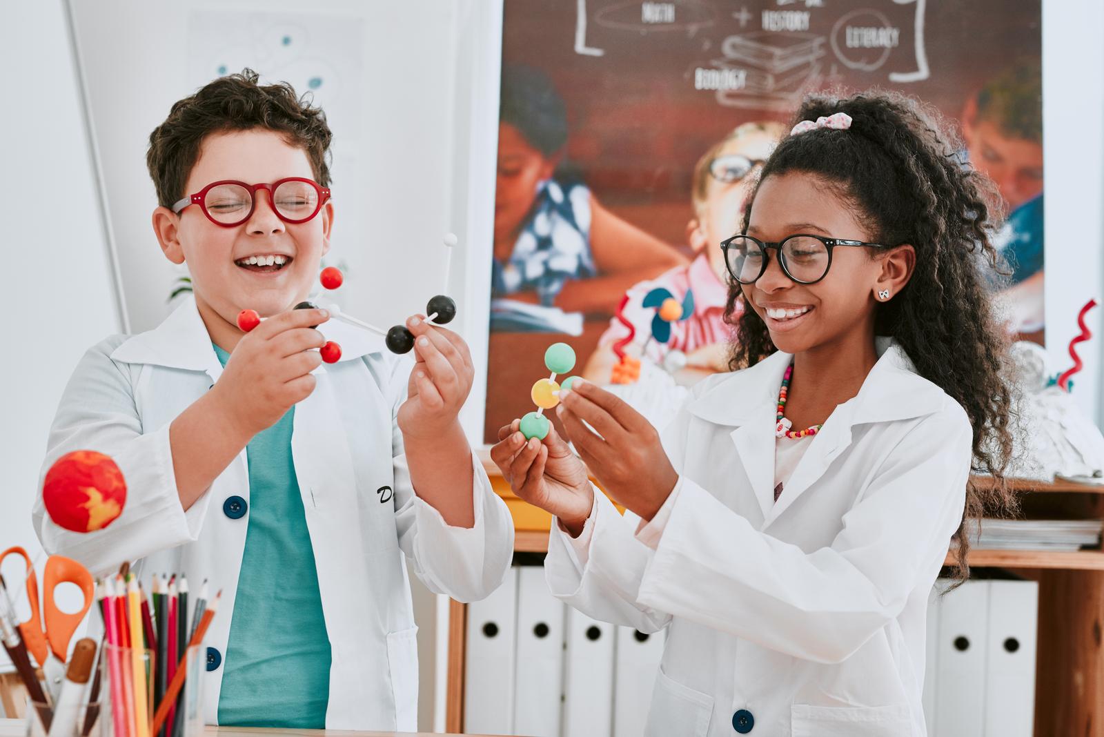 Shot of two adorable young school children learning about molecules in science class at school.